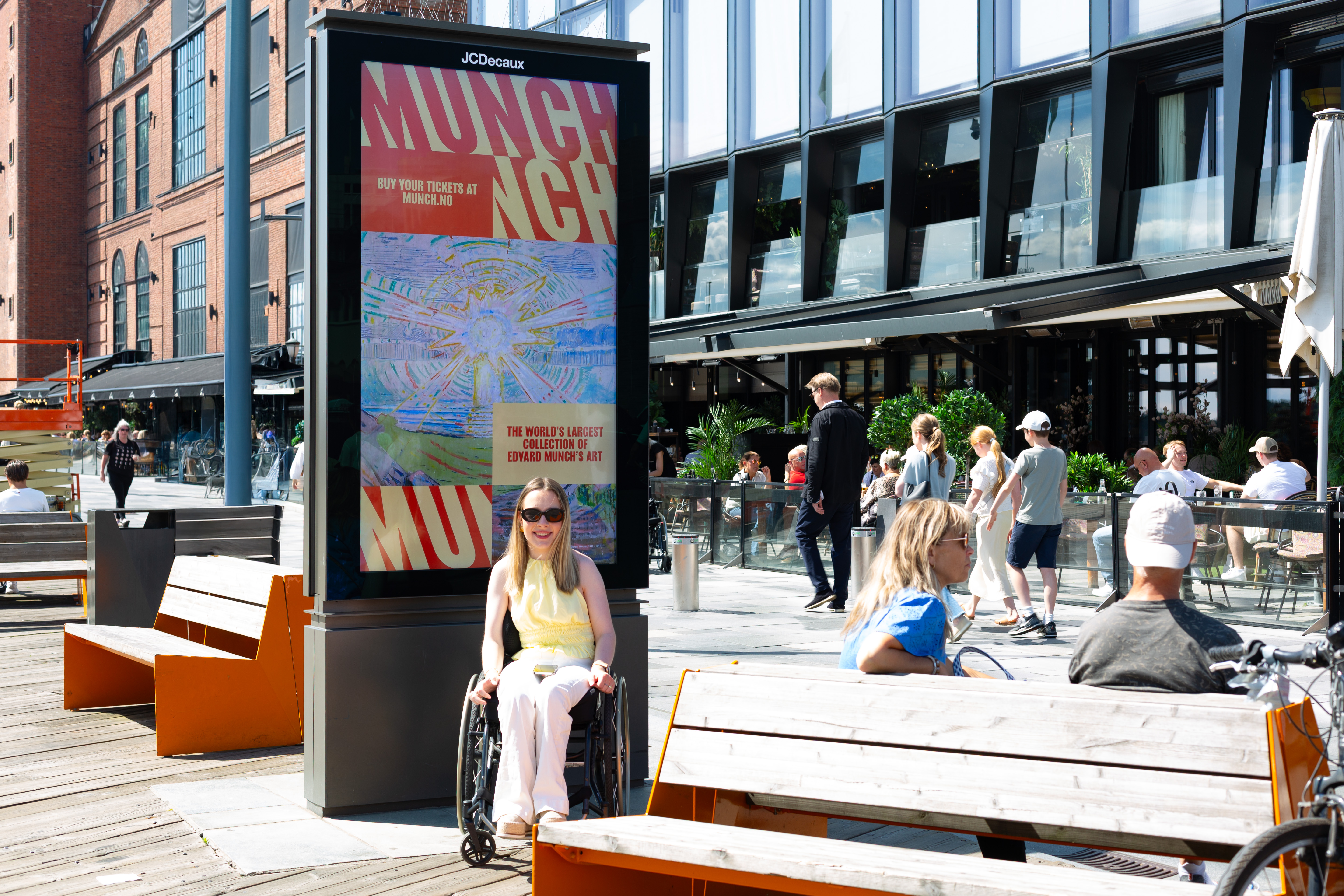 Mie-2 Sommervikar i JCDecaux, Mie, sitter foran en reklame for Munch på Aker Brygge.