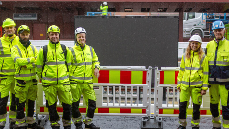 Teamet i JCDecaux står foran den nye X-Track Premium-skjermen på Majorstuen T-banestasjon.