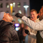 Kjartan Skjelde mater Grunde Myhrer med surstrømming.